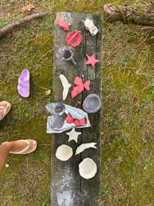 Crianças a moldar figuras em barro numa atividade ao ar livre da Criar Eventos.